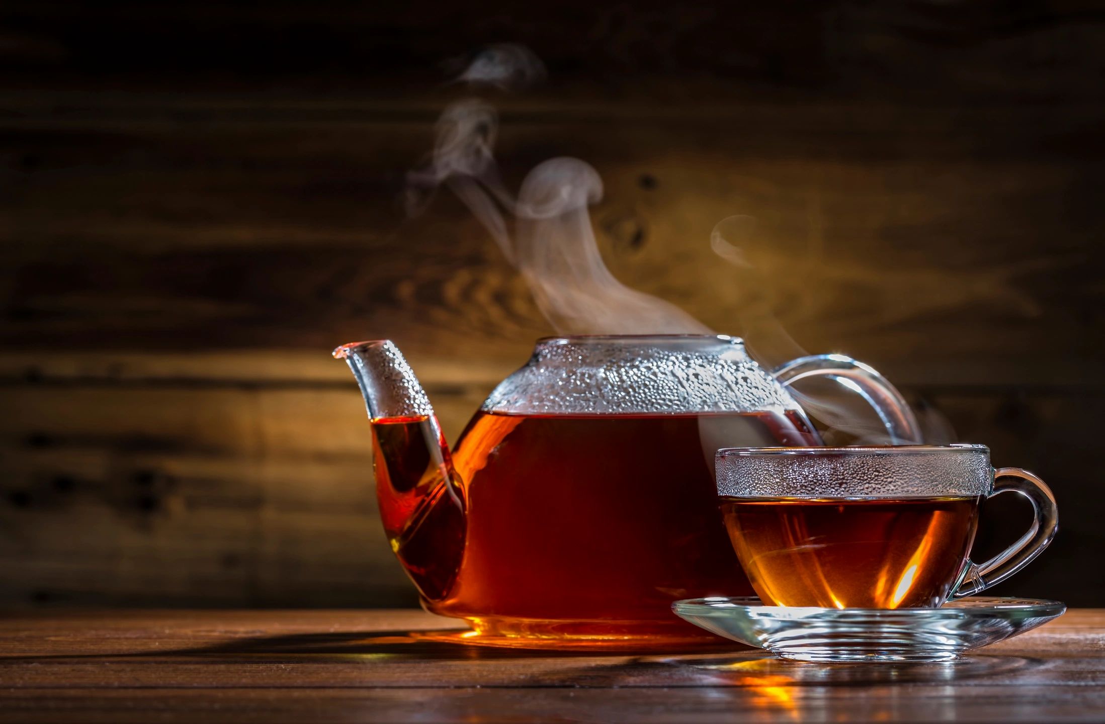 Glass teapot with amber tea for catering