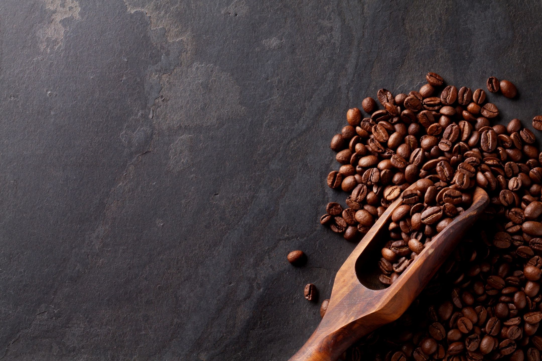 Roasted coffee beans with wooden scoop